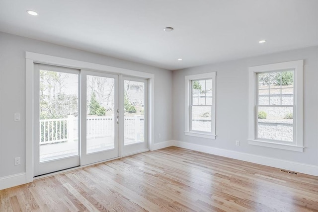 empty room featuring visible vents, recessed lighting, baseboards, and wood finished floors