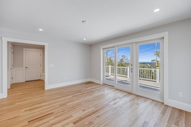 spare room featuring recessed lighting, baseboards, and light wood-style flooring
