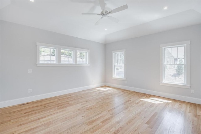 spare room featuring baseboards, a ceiling fan, light wood-type flooring, and visible vents