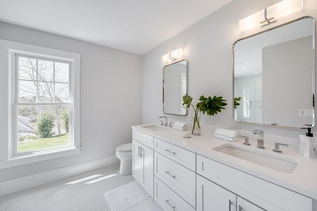 full bath featuring baseboards, plenty of natural light, and a sink