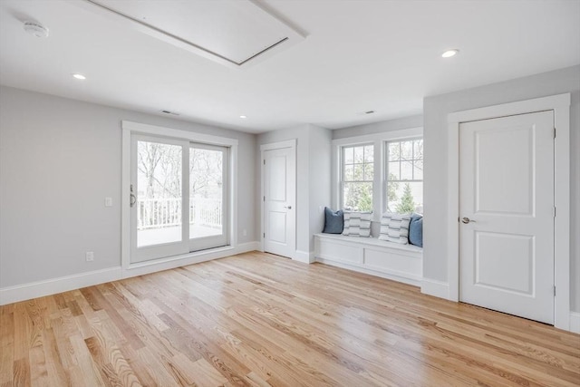 unfurnished living room with baseboards, a healthy amount of sunlight, and light wood-style floors