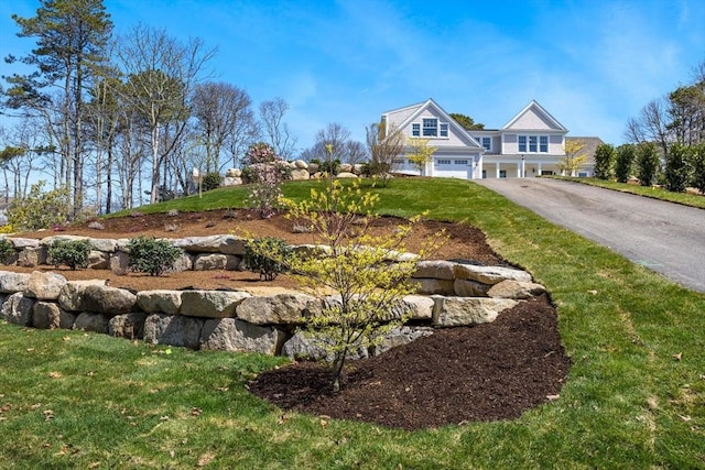 view of front of property with an attached garage, a front lawn, and driveway