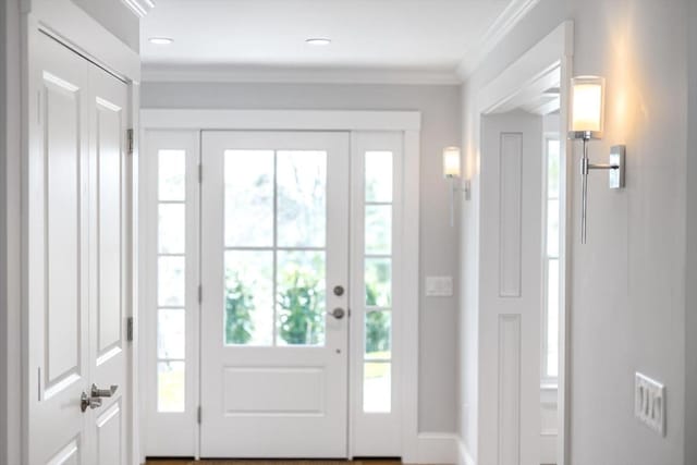 doorway with crown molding and recessed lighting