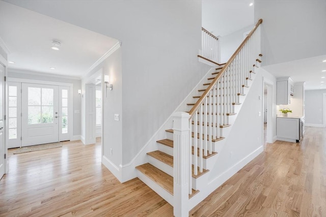 foyer entrance with stairway, baseboards, light wood-style floors, ornamental molding, and recessed lighting