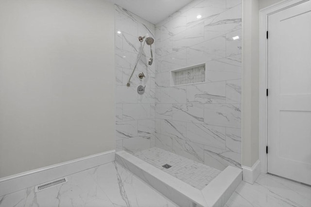 full bath with visible vents, baseboards, marble finish floor, and a tile shower