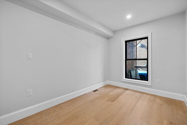 empty room with visible vents, baseboards, and light wood-style floors