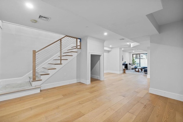 below grade area featuring visible vents, baseboards, stairs, recessed lighting, and hardwood / wood-style flooring