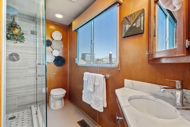 full bath featuring tile patterned flooring, a shower stall, vanity, and toilet