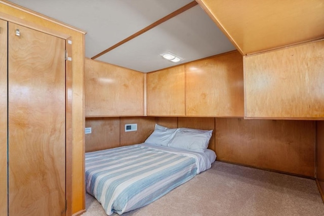 carpeted bedroom featuring wood walls