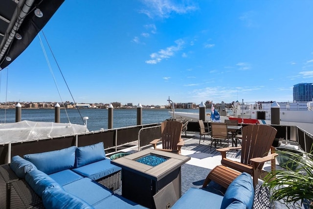 view of patio with an outdoor living space with a fire pit and a water view