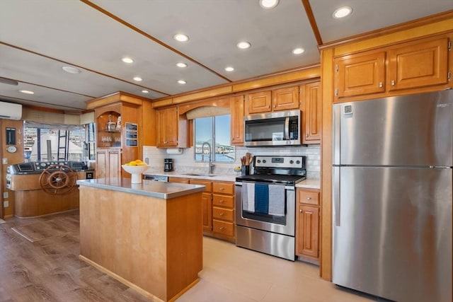 kitchen featuring a sink, stainless steel appliances, a kitchen island, and decorative backsplash