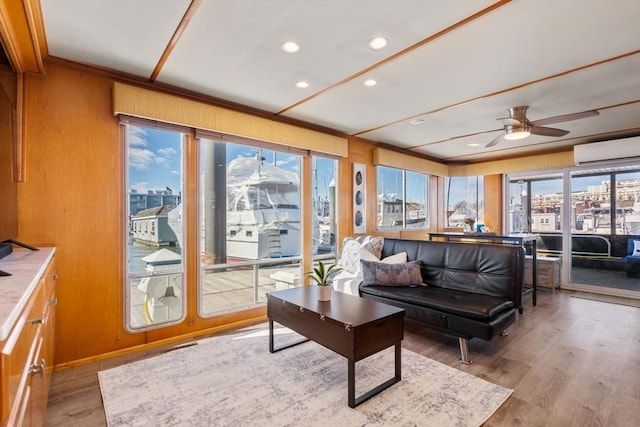 sunroom with a view of city, an AC wall unit, and a ceiling fan