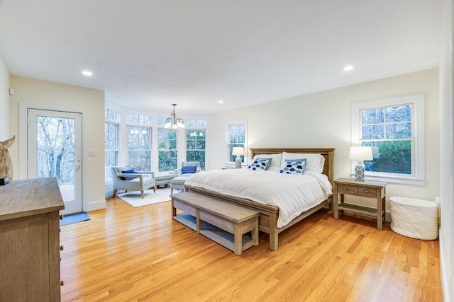 bedroom featuring light wood-style floors, recessed lighting, access to exterior, and an inviting chandelier