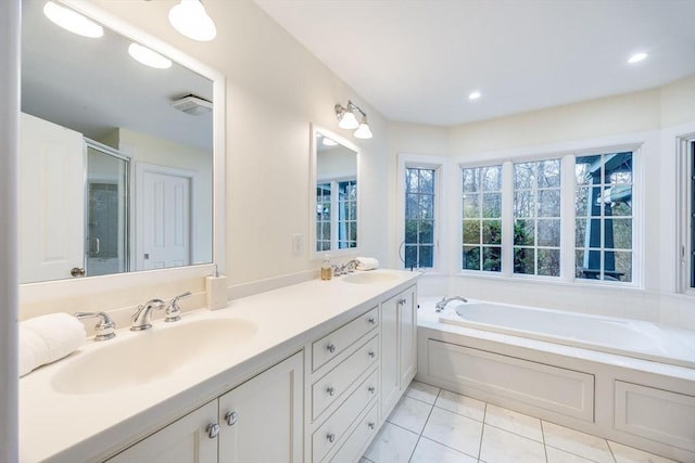 bathroom featuring double vanity, a stall shower, a sink, a bath, and tile patterned floors