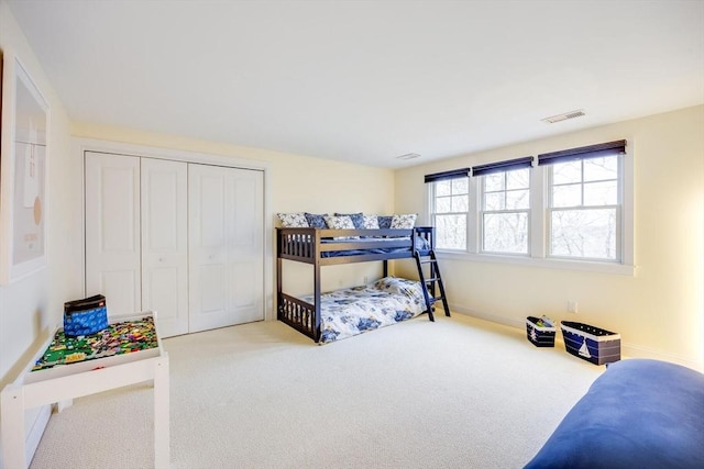 carpeted bedroom featuring a closet and visible vents