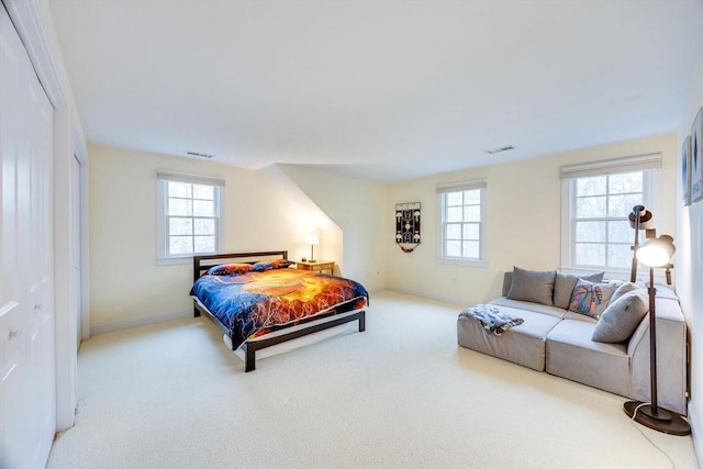 carpeted bedroom featuring visible vents, baseboards, and multiple windows