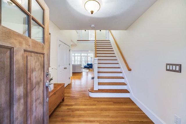 staircase with baseboards and wood finished floors