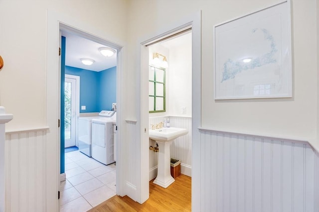 bathroom with a healthy amount of sunlight, wainscoting, wood finished floors, and independent washer and dryer