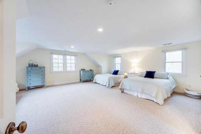 carpeted bedroom with vaulted ceiling, multiple windows, and visible vents