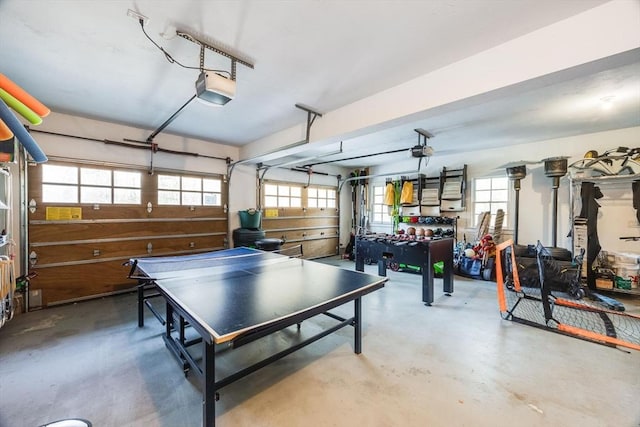 game room with a garage, plenty of natural light, and finished concrete flooring