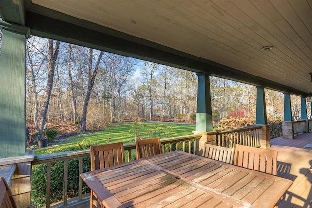 wooden terrace with a yard and outdoor dining area