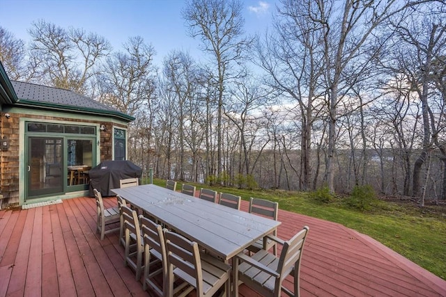 wooden terrace with a yard, grilling area, and outdoor dining space