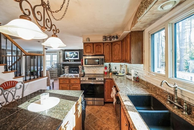 375 Winchendon Rd, Ashburnham, MA 01430 - kitchen featuring stainless steel appliances, brown cabinetry, backsplash, pendant lighting, and tile counters