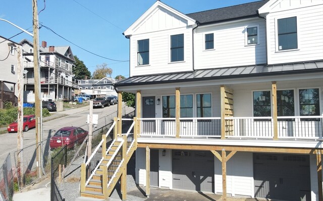 back of house with covered porch and a garage