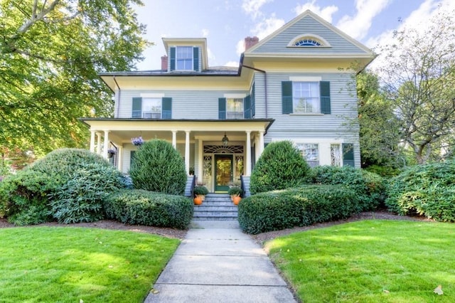 victorian home featuring a porch and a front yard