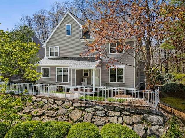 rear view of house with a shingled roof and fence private yard