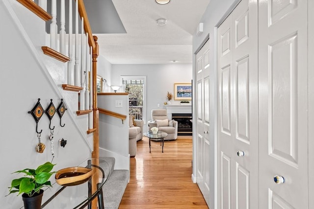 hallway featuring light wood-type flooring and stairs