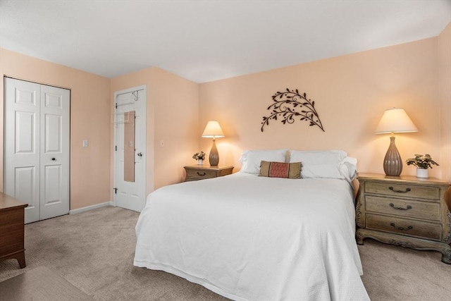 carpeted bedroom with baseboards and a closet