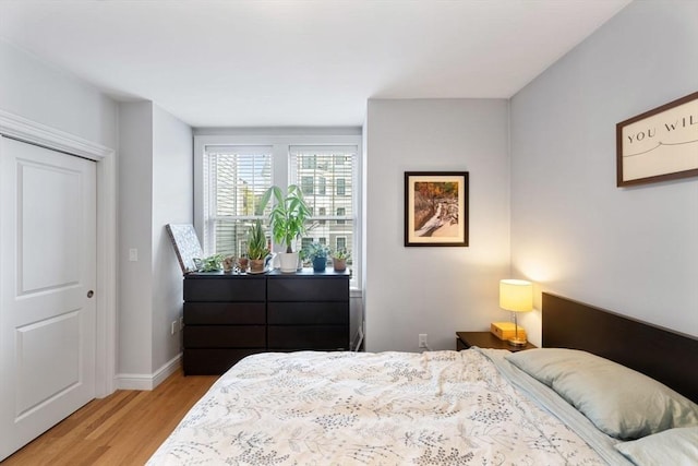 bedroom featuring baseboards and light wood-style flooring