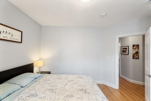 bedroom with light wood-style floors and baseboards