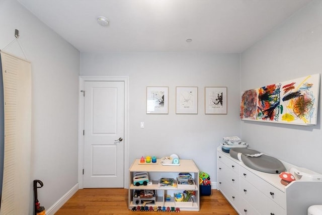 rec room featuring baseboards and light wood-type flooring