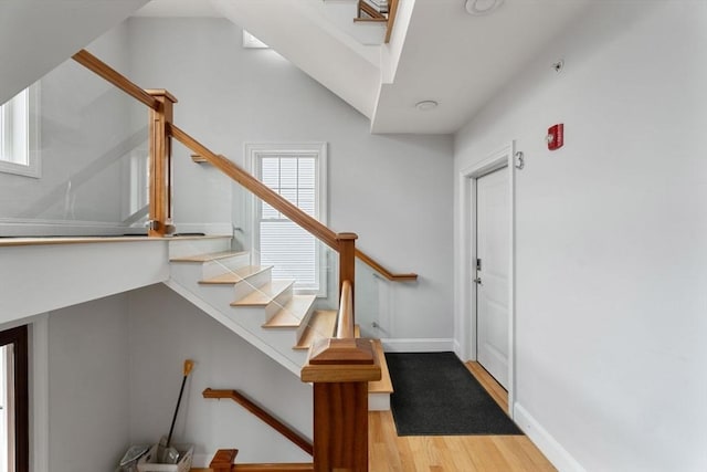staircase with baseboards and wood finished floors