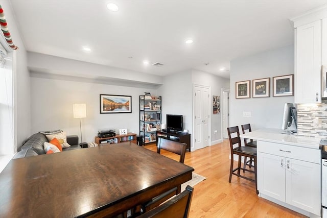 dining area featuring visible vents, light wood-style flooring, and recessed lighting