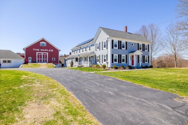 colonial home with a front lawn and a chimney