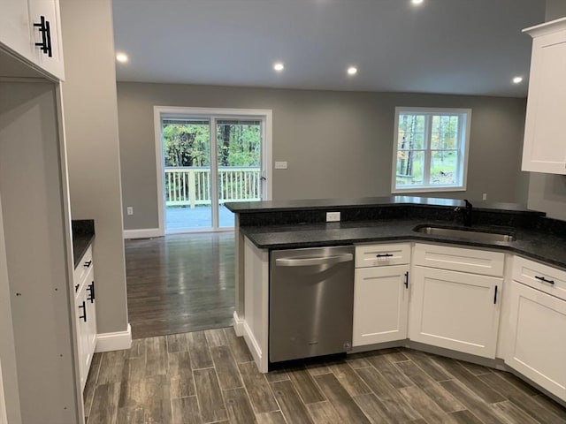 kitchen with dishwasher, sink, white cabinets, dark stone counters, and plenty of natural light