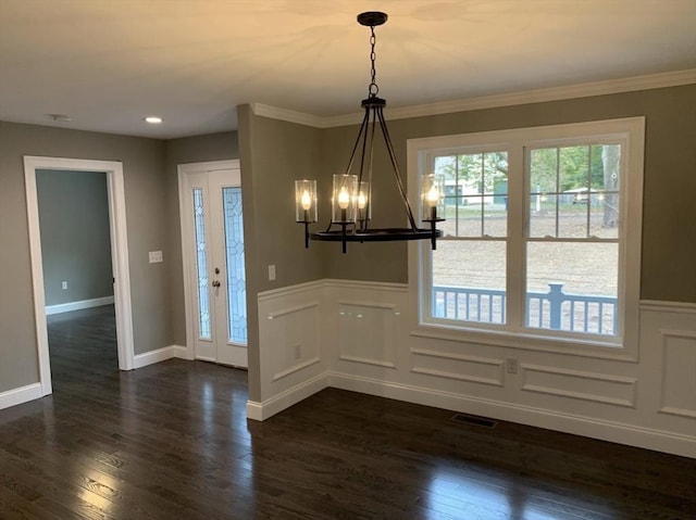 unfurnished dining area featuring ornamental molding, dark hardwood / wood-style floors, and a chandelier