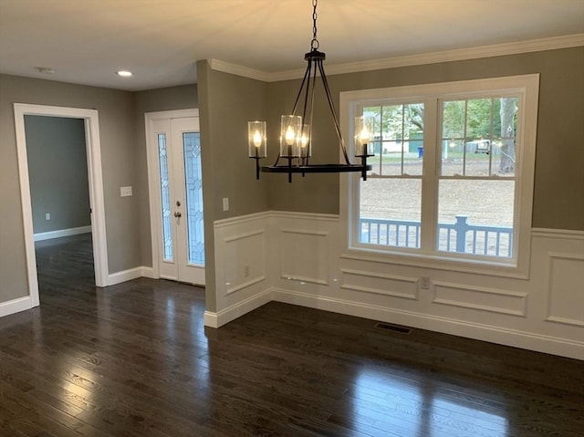 unfurnished dining area featuring ornamental molding, dark hardwood / wood-style floors, and a chandelier