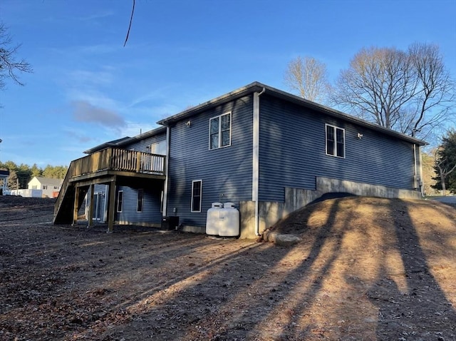 view of side of home with central AC and a wooden deck