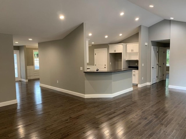 kitchen featuring lofted ceiling, dark hardwood / wood-style floors, white cabinets, and kitchen peninsula