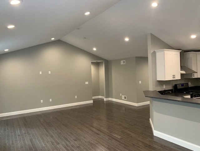 kitchen featuring lofted ceiling, white cabinets, dark hardwood / wood-style flooring, stainless steel range with electric stovetop, and kitchen peninsula