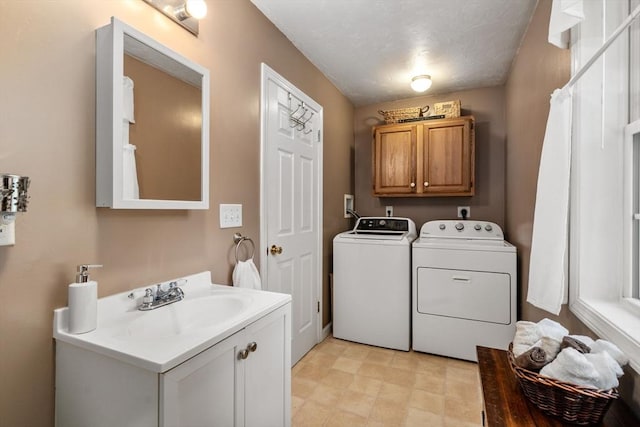 laundry area with cabinet space, washer and dryer, light floors, and a sink