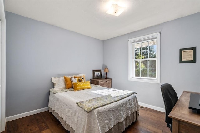 bedroom with baseboards and wood finished floors