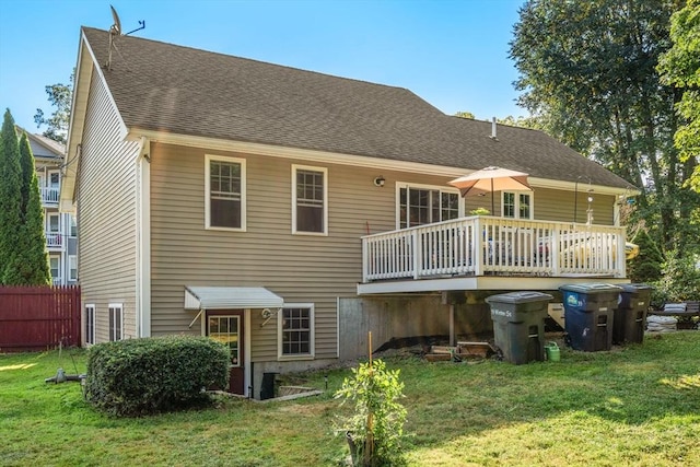 rear view of house with a lawn and a shingled roof