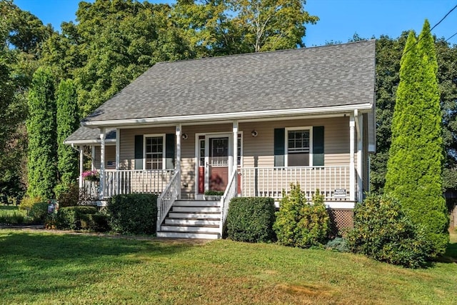 view of front of property with a porch, a shingled roof, and a front lawn