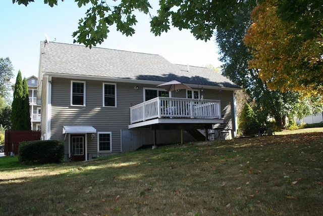 back of property with a yard and a wooden deck