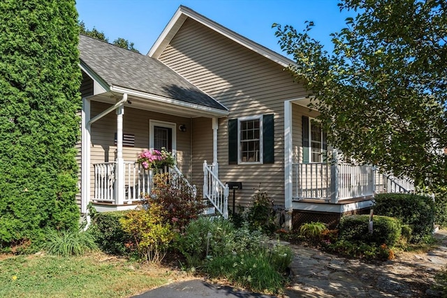 bungalow with a porch and roof with shingles